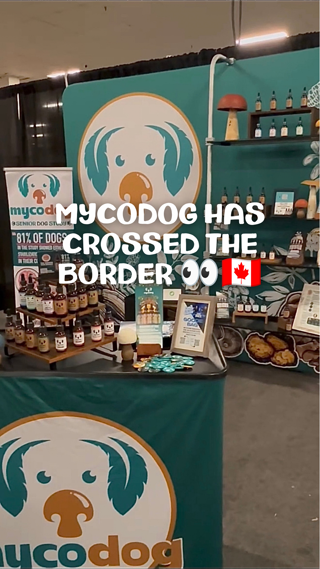 A booth displaying Mycodog products, featuring a teal backdrop with the company logo. Text overlay announces Mycodog's expansion into Canada.