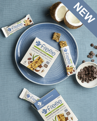 Image of Freee's new coconut and chocolate oat bars. The scene includes the packaging, individual bars, a split coconut, and chocolate chips on a blue background, conveying a fresh and natural look.