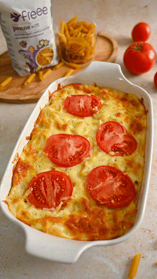 A deliciously baked pasta dish topped with fresh tomato slices and cheese. The scene exudes a warm and appetizing feel, ready to be served.